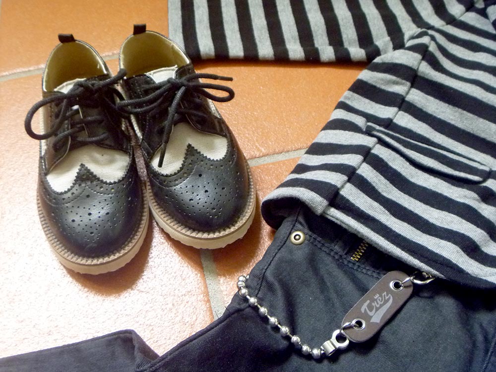 look bambino in stile rock con giacca in felpa a righe, jeans neri e scarpe bicolor modello college