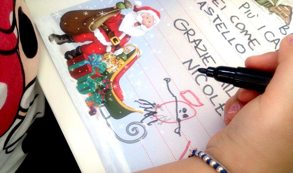 bambina scrive la sua letterina a babbo natale chiedendo un giocattolo di frozen disney